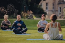 Group of people enjoying a guided meditation in the sun