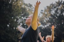 Group of people enjoying a guided meditation in the sun