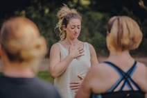 Group of people enjoying a guided meditation in the sun