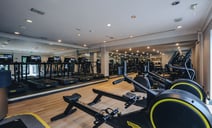 Interior view of a gym showcasing exercise machines and mirrors, creating an open and motivating workout environment.