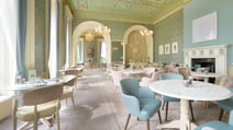 A beautifully arranged dining room in the Wedgewood Room at Heythrop Park, with many tables and chairs for dining.