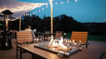 The terrace at Holme Lacy House at dusk, featuring warming fire pits
