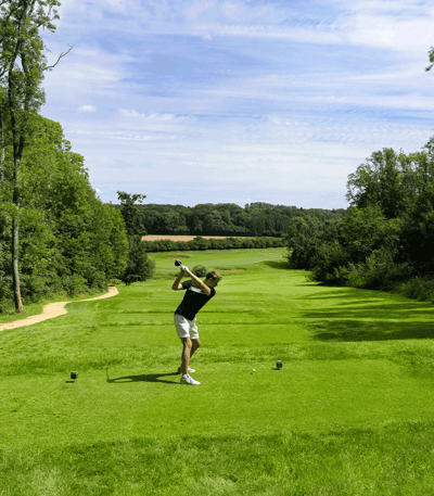 Golfer perfecting his swing on the green golf course at Heythrop Park.