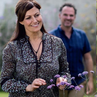 A couple enjoying a sunny day in a lavender field, standing close together amidst the beautiful purple blooms.