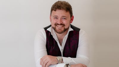 Portrait of Jack Ollett, smiling man with a beard, wearing a white shirt.