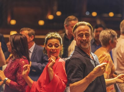 A man and woman joyfully dancing together at a lively party in Heythrop Park, capturing the spirit of celebration