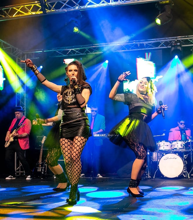 Immerse yourself in the electrifying 80s Explosion at Warner Hotels as the band and singers on stage captivate the audience.