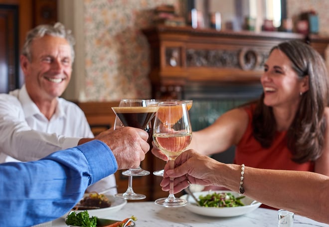 Guests making a toast over a delicious meal that they share in the Brasserie32 at Thoresby Hall Hotel