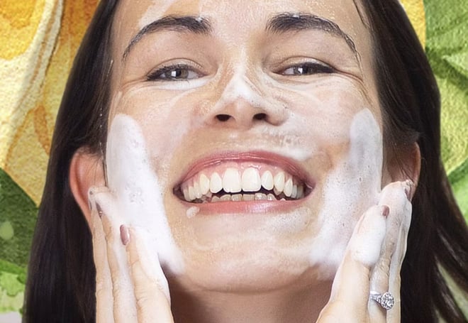 A woman applying cleaner to her face