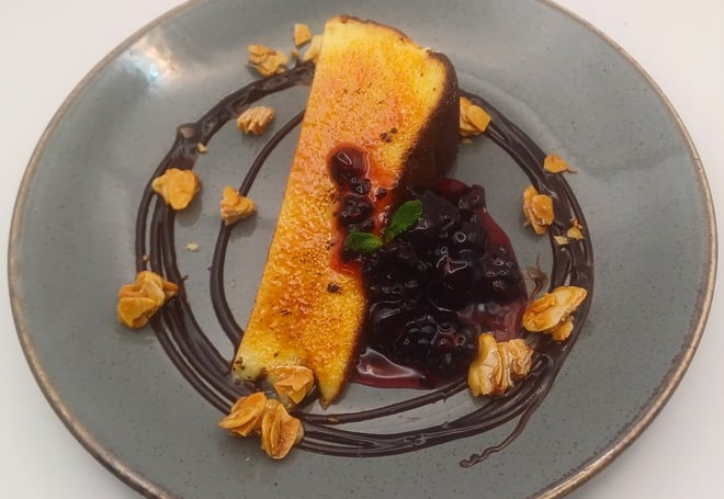 Brûléed Basque cheesecake: Creamy, caramelised perfection, served with blackberry and cherry compote, almond brittle and chocolate sauce.