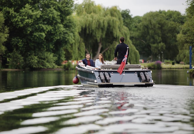 A couple enjoy a romantic boat trip along the River Thames during their stay at The Runnymede on Thames Hotel