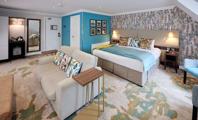 A hotel room featuring blue walls and a neatly made bed, creating a serene and inviting atmosphere for guests