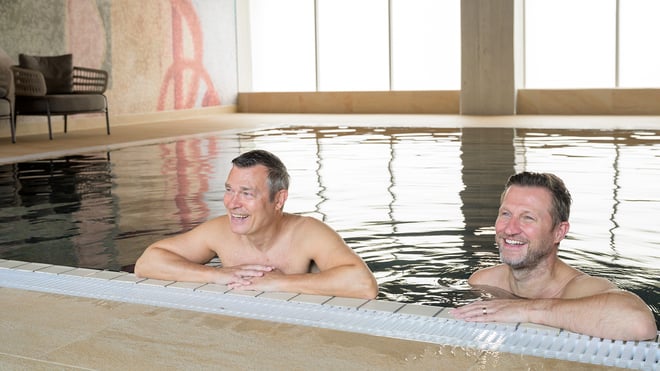 Two guests relaxing in the pool at Heythrop Park Hotel