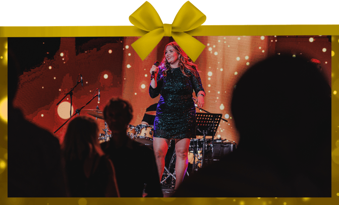 Performer on stage in front of a red sparkly background