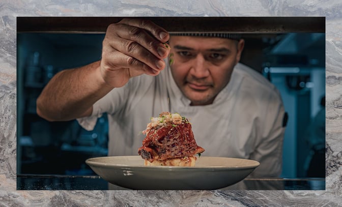 Warner Hotels chef adding the finishing touches to a main meal