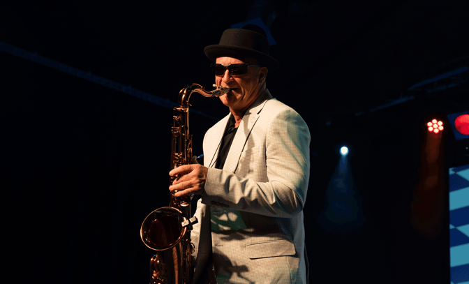 Bad Ska Madness playing the sax on stage with sunglasses