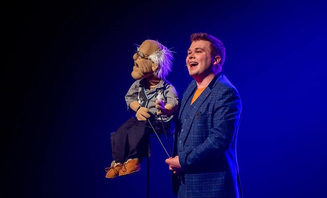 Max Fulham on stage with puppet