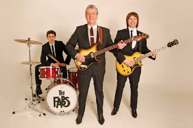 The Fabs, standing with their guitars