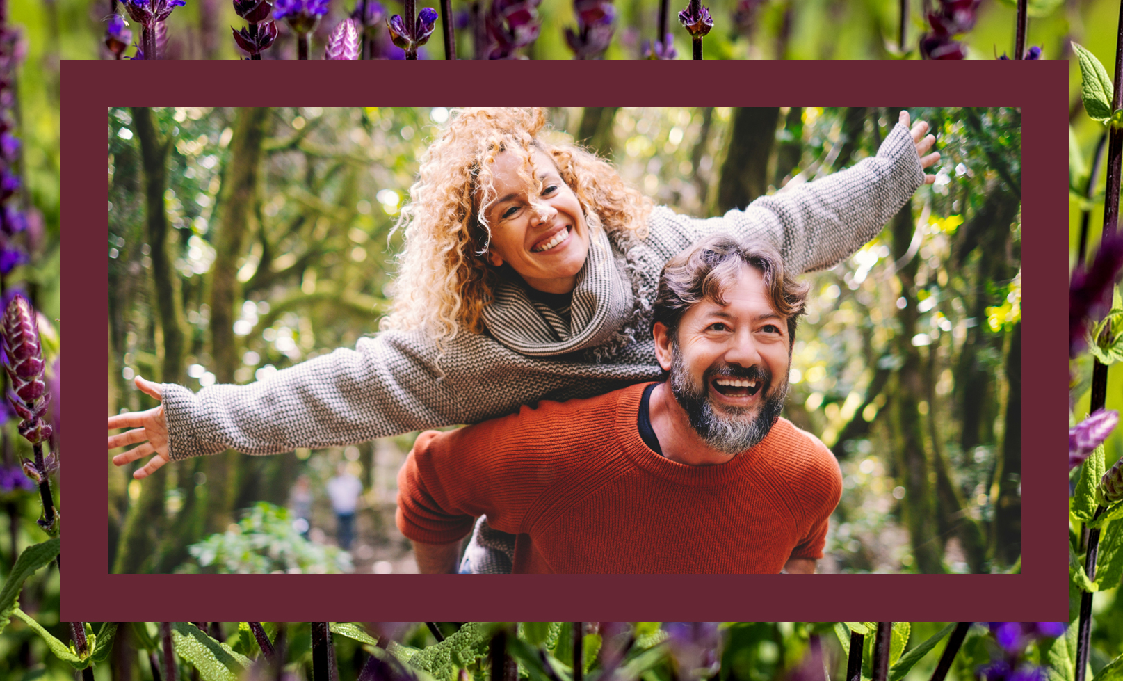 A couple, where the man has the woman on his back and she pretends to fly, both smiling gleefully